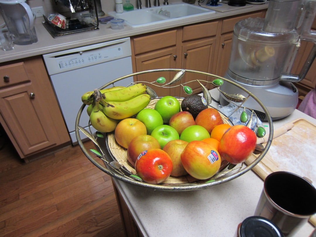 A bowl of assorted fruits on a kitchen counter